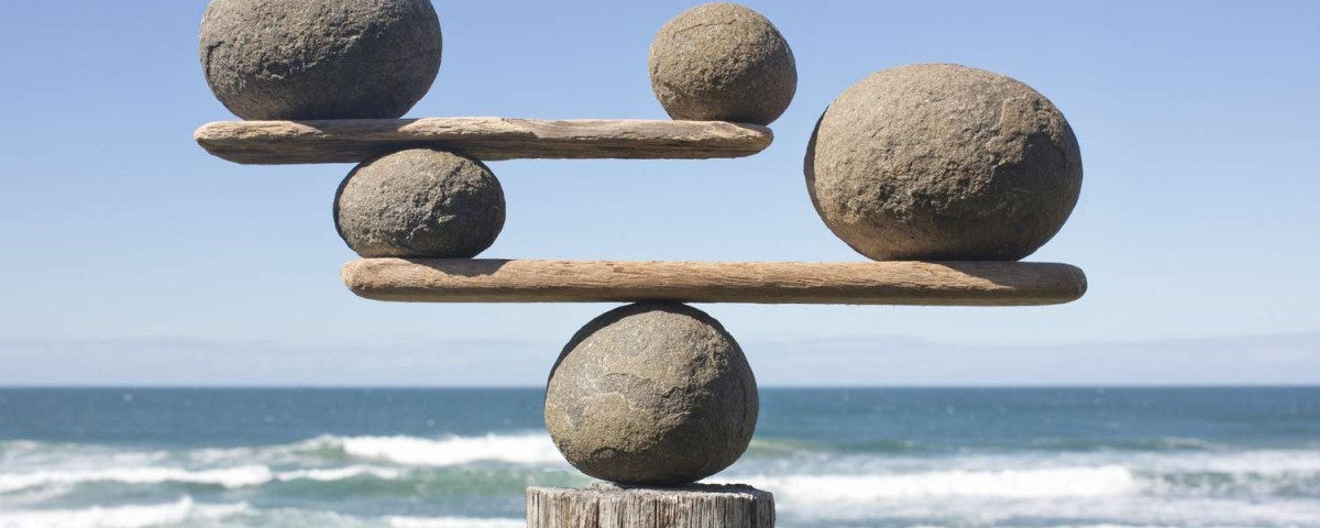 rocks-balancing-on-driftwood--sea-in-background-153081592-591bbc3f5f9b58f4c0b7bb16