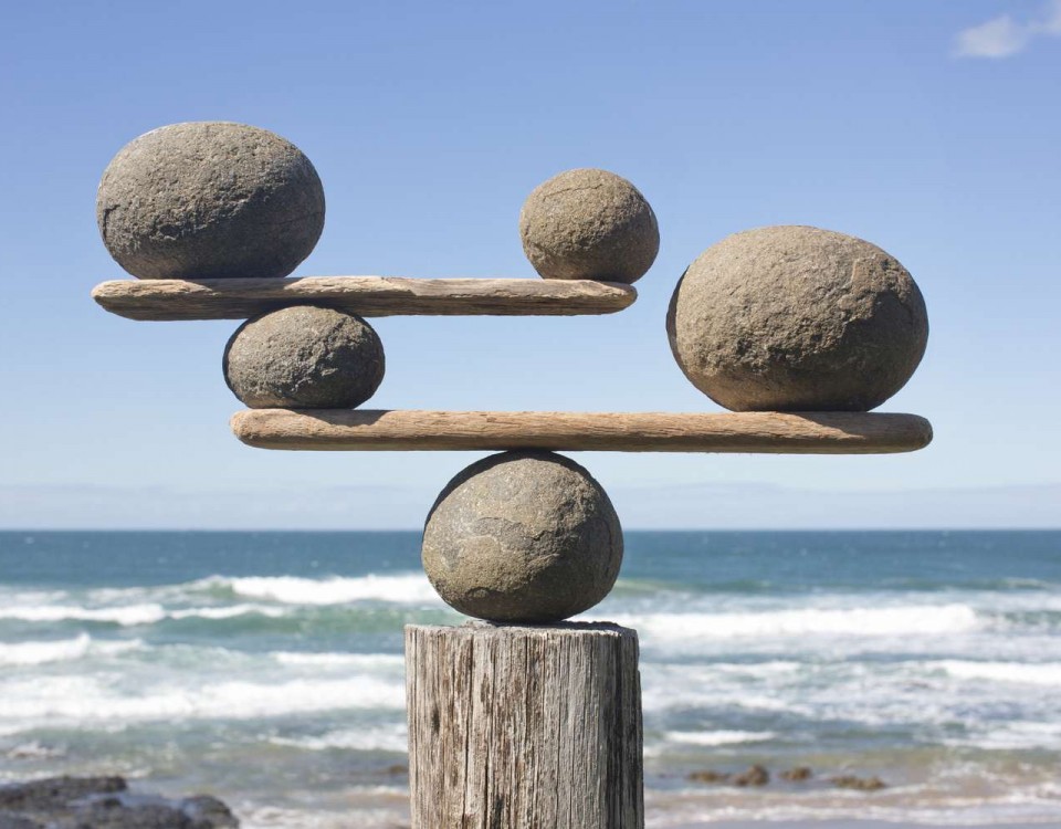 rocks-balancing-on-driftwood--sea-in-background-153081592-591bbc3f5f9b58f4c0b7bb16